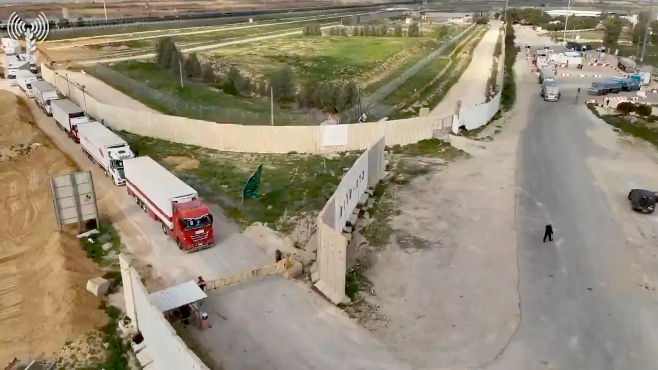 Humanitarian aid trucks wait in line to be inspected at the Kerem Shalom crossing, COGAT via X/Handout via Reuters/File Photo