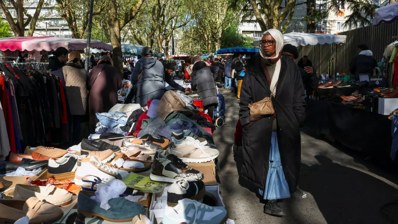 A shopper walks through the 800 metre-long Tuesday Market in Sarcelles, which has vendors selling food, clothing, homeware products and handicrafts to cater for Sarcelles' diverse immigrant community in the Paris suburb of Sarcelles, France, April 14, 2026. Reuters/Tom Nicholson