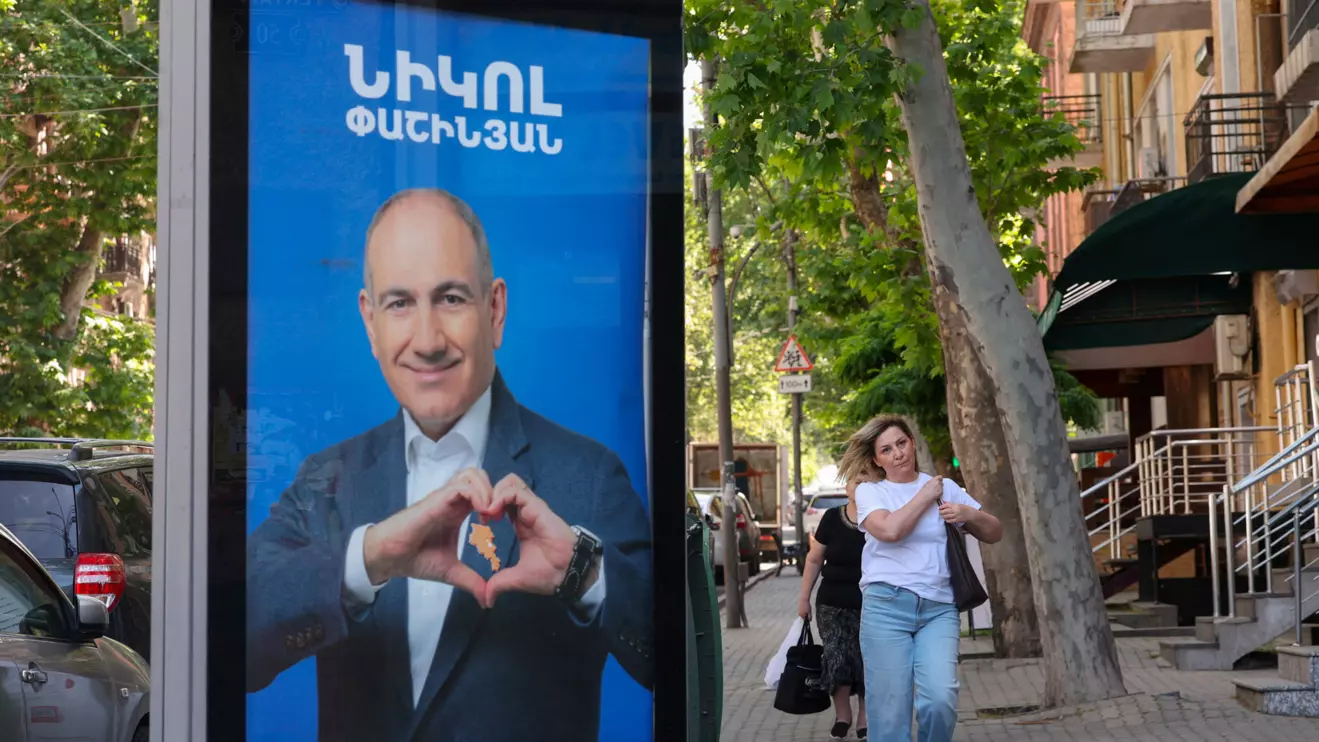 People walk past campaign banners with portraits of Prime Minister Nikol Pashinyan of the Civil Contract party, ahead of the June 7 parliamentary election, in Yerevan, Armenia June 3, 2026. Hayk Baghdasaryan/Photolure via Reuters