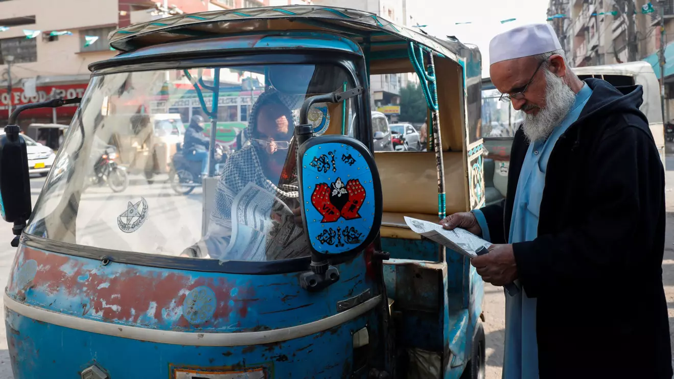 Men read newspapers, after the Pakistani foreign ministry said the country conducted strikes targeting separatist militants inside Iran, along a road in Karachi, Pakistan January 18, 2024. ReutersAkhtar Soomro