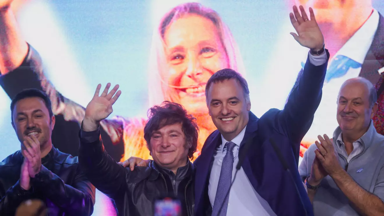 Argentina's President Javier Milei and presidential spokesman and legislative candidate in the city of Buenos Aires Manuel Adorni wave and embrace onstage at the La Libertad Avanza party headquarters on the day of the legislative elections of the city of Buenos Aires, Argentina, May 18, 2025. Reuters/Tomas Cuesta