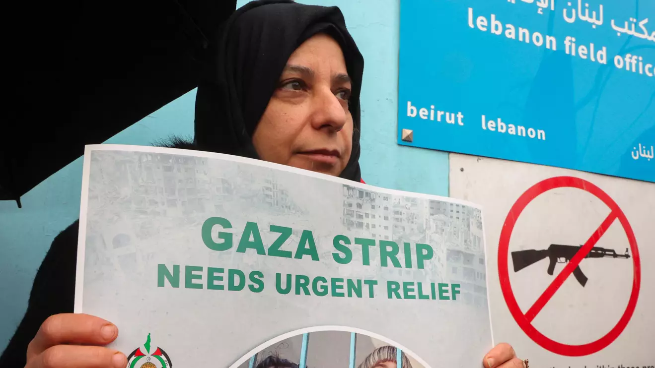A Palestinian woman holds a placard during a protest against the suspension of UNRWA funding by some Western states, in front of the United Nations Palestinian aid agency UNRWA's building in Beirut, Lebanon January 30, 2024. Reuters/Mohamed Azakir