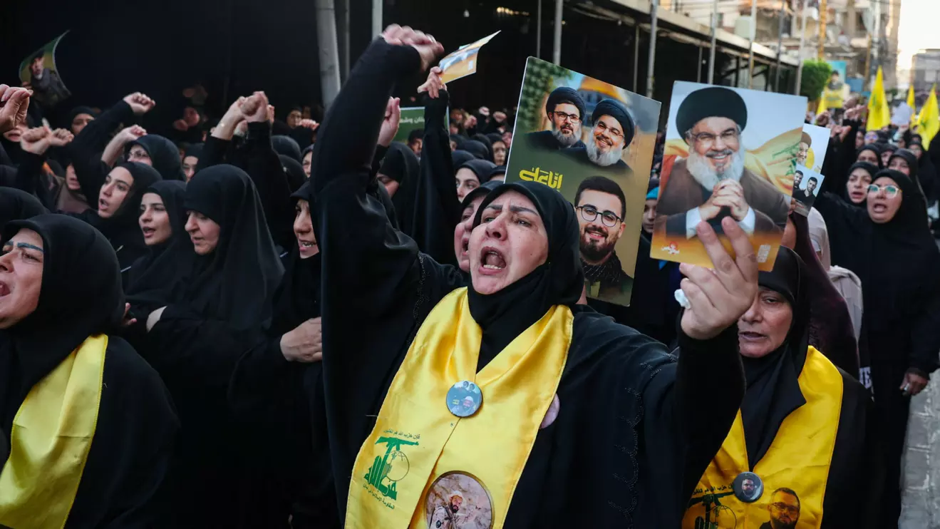 A woman holds a picture of late Hezbollah leader Hassan Nasrallah during the funeral of Hezbollah's top military official, Haytham Ali Tabtabai, and of other people who were killed by an Israeli airstrike on Sunday, despite a U.S.-brokered truce a year ago, in Beirut's southern suburbs, Lebanon November 24, 2025. Reuters/Mohamed Azakir