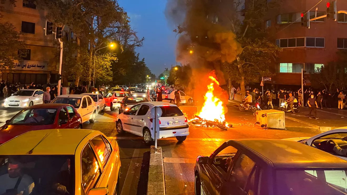 A police motorcycle burns during a protest over the death of Mahsa Amini, a woman who died after being arested by the Islamic republic's "morality police", in Tehran, Iran September 19, 2022. WANA (West Asia News Agency) via Reuters