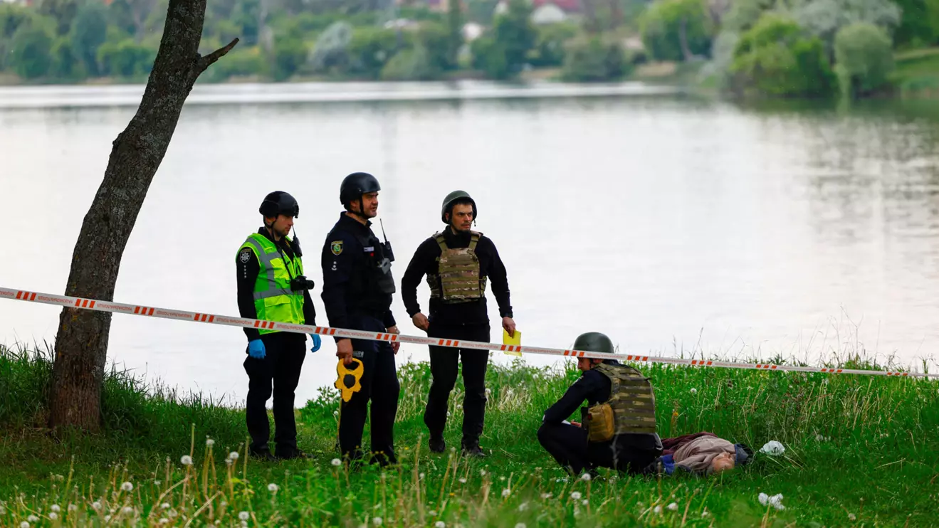 Police officers inspect the body of a man killed by a Russian missile strike on the bank of a lake, amid Russia's attack on Ukraine, in Kharkiv, May 19, 2024. Reuters/Valentyn Ogirenko