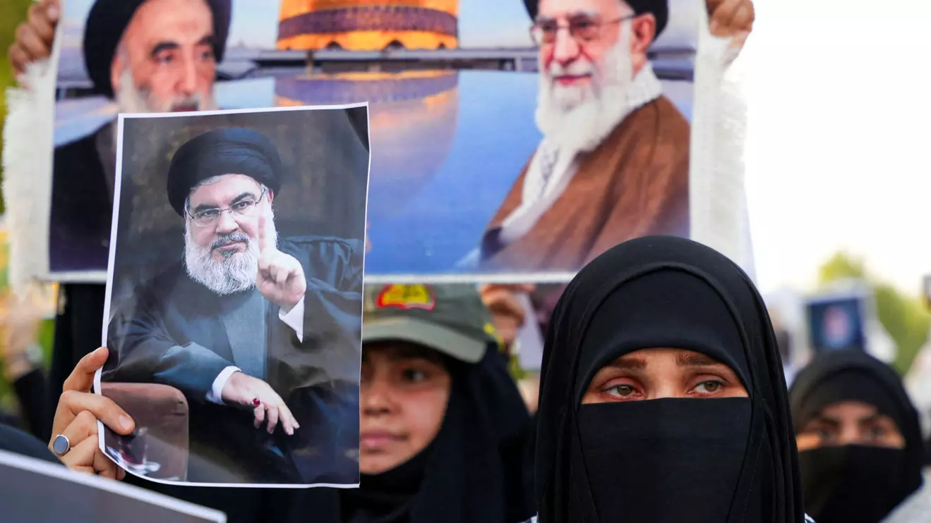 A woman holds a picture of Lebanon's Hezbollah Chief Hassan Nasrallah who was killed by an Israeli airstrike in Beirut, during a symbolic funeral in Basra, Iraq, September 29, 2024. Reuters/Essam al-Sudani