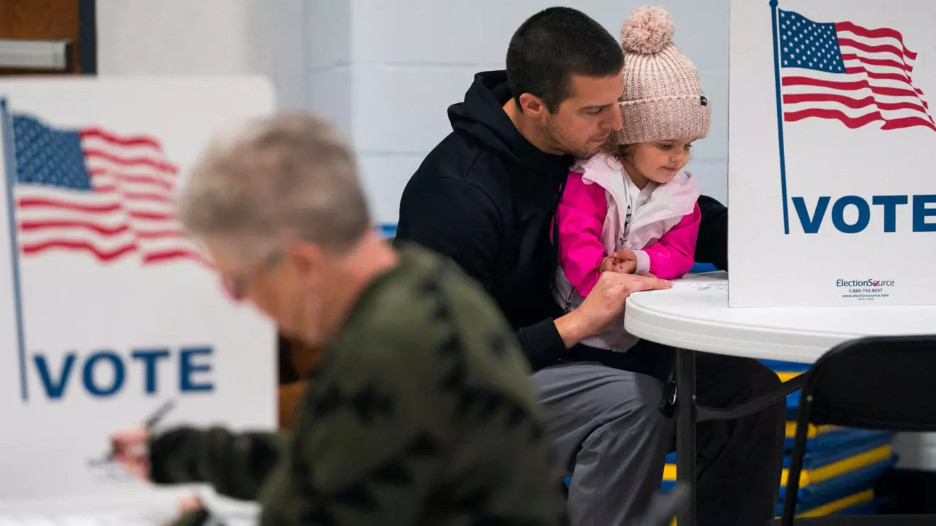 Dustin Ritchie, 34, votes with his daughter in the U.S. presidential election on Election Day at the Douglas County Central Assembly of God polling location in Superior, Wisconsin, U.S., November 5, 2024. Reuters/Erica Dischino