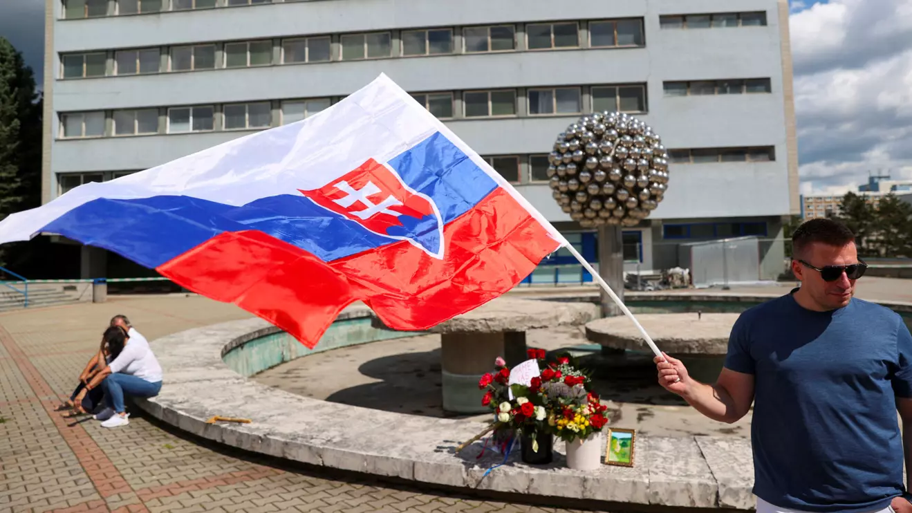 A supporter holds a flag of Slovakia near the F.D. Roosevelt University Hospital, where Slovak Prime Minister Robert Fico is hospitalised following an assassination attempt, in Banska Bystrica, Slovakia, May 18, 2024. Reuters/Bernadett Szabo