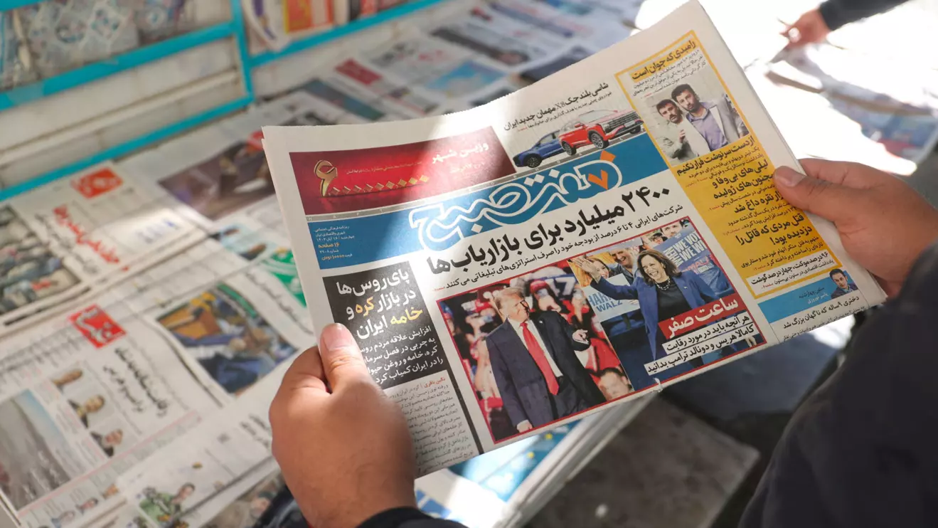 An Iranian man looks at a newspaper with a picture of Republican presidential nominee and former U.S. President Donald Trump and Democratic presidential nominee U.S. Vice President Kamala Harris, in Tehran, Iran November 6, 2024. Majid Asgaripour/WANA (West Asia News Agency) via Reuters