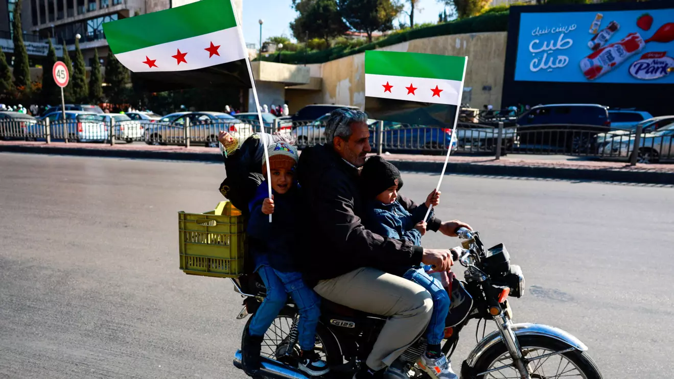 A man rides a motorbike with children holding up flags adopted by the new Syrian rulers, after Syria's Bashar al-Assad was ousted, in Damascus, Syria, December 15, 2024. Reuters/Ammar Awad