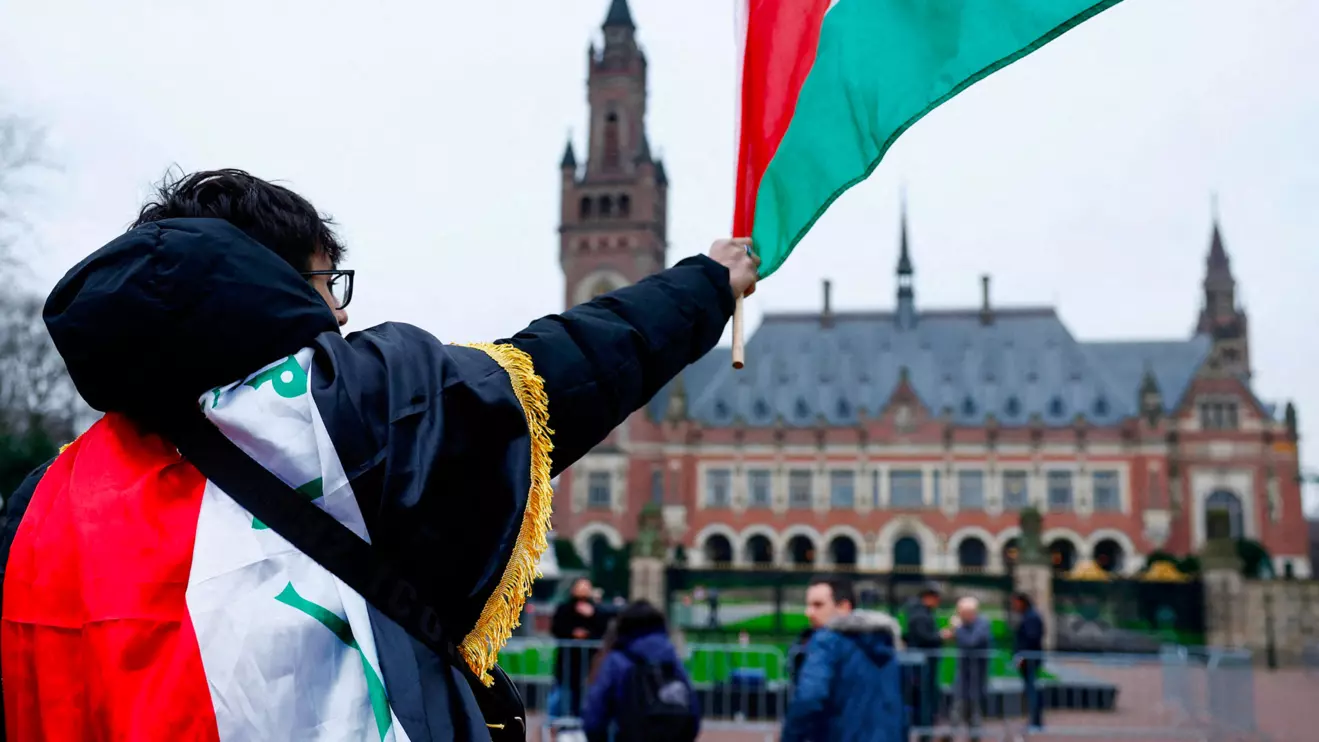 A man waves a Palestinian flag as people protest on the day of a public hearing held by The International Court of Justice (ICJ) to allow parties to give their views on the legal consequences of Israel's occupation of Palestinian territories before eventually issuing a non-binding legal opinion, in The Hague, Netherlands, February 21, 2024. Reuters/Piroschka van de Wouw/File Photo