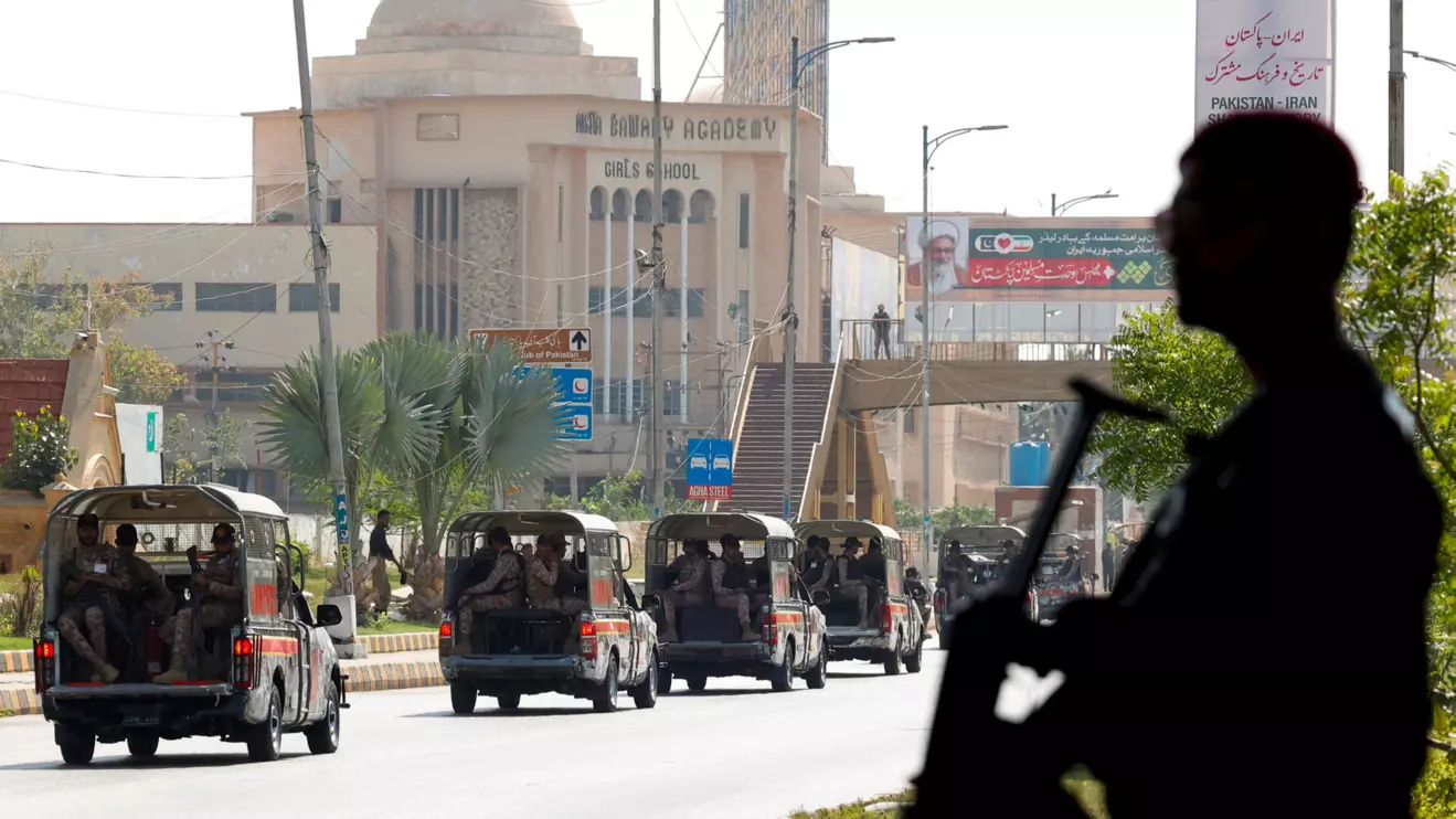 A police officer is silhouetted as he stands guard while paramilitary forces patrol as a security measure, following the visit of the Iranian President Ebrahim Raisi, in Karachi, Pakistan April 23, 2024. Reuters/Akhtar Soomro