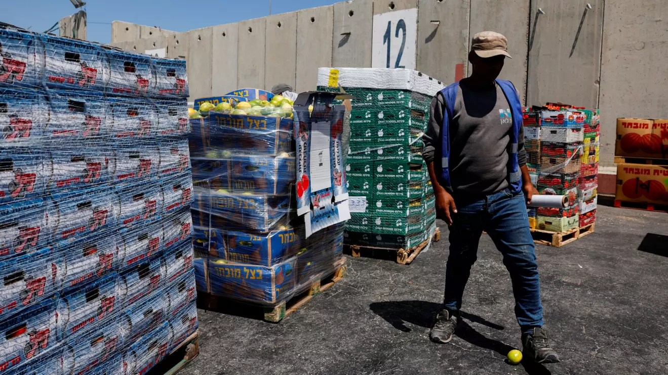 A man walks next to humanitarian aid destined for the Gaza Strip, amid the ongoing conflict in Gaza between Israel and Hamas, at the Kerem Shalom crossing in southern Israel, July 10, 2024. Reuters/Amir Cohen