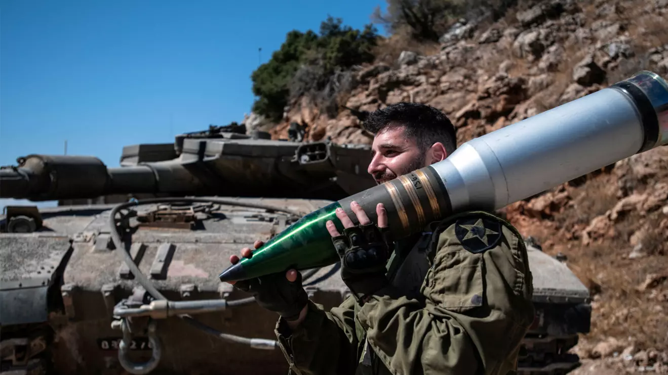 An Israeli soldier carries a shell, amid cross-border hostilities between Hezbollah and Israel, in northern Israel, October 7, 2024. Reuters/Gil Eliyahu