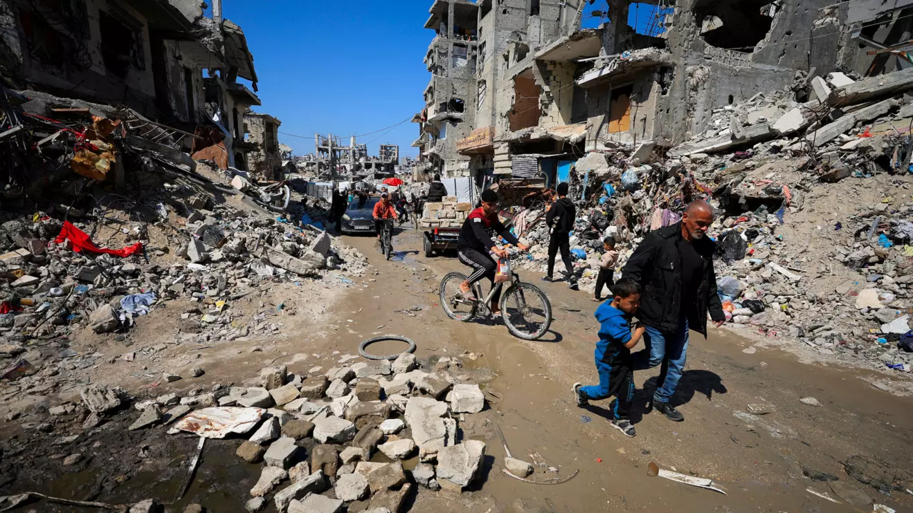 Palestinians pass by the rubble of destroyed houses, in Gaza City, March 11, 2025. Reuters/Dawoud Abu Alkas