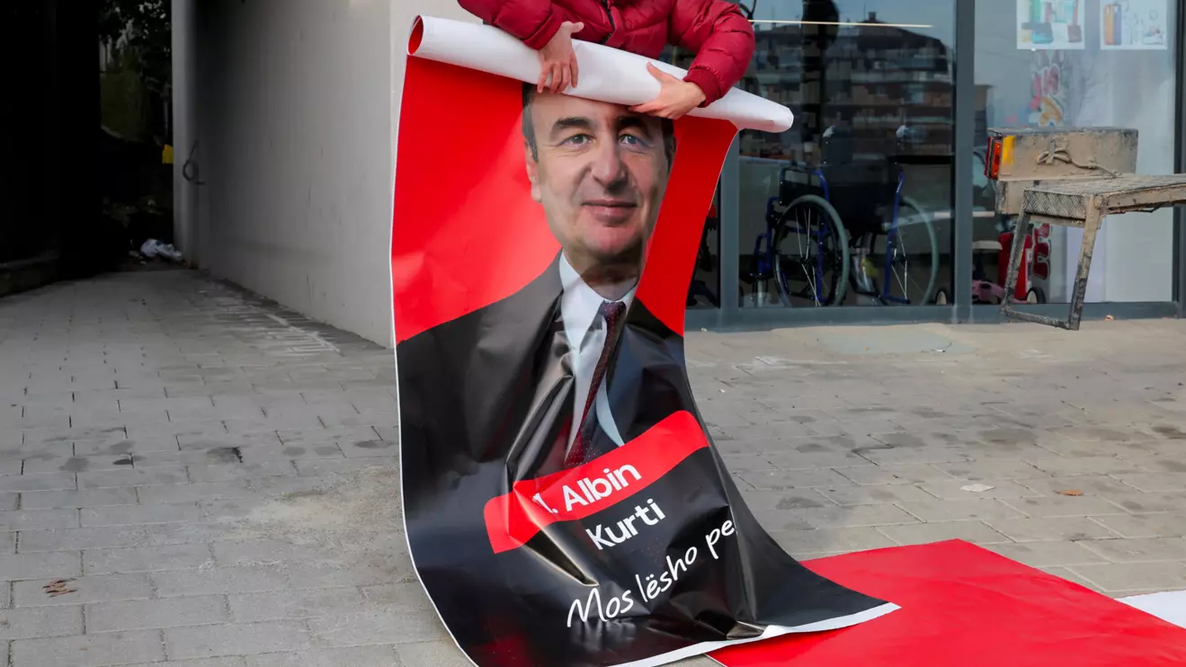 A worker holds an election campaign poster with a portrait of acting Prime Minister of Kosovo and Levizja Vetevendosje (Movement for Self-Determination) party leader Albin Kurti, in Pristina, Kosovo December 16, 2025, Reuters/Valdrin Xhemaj