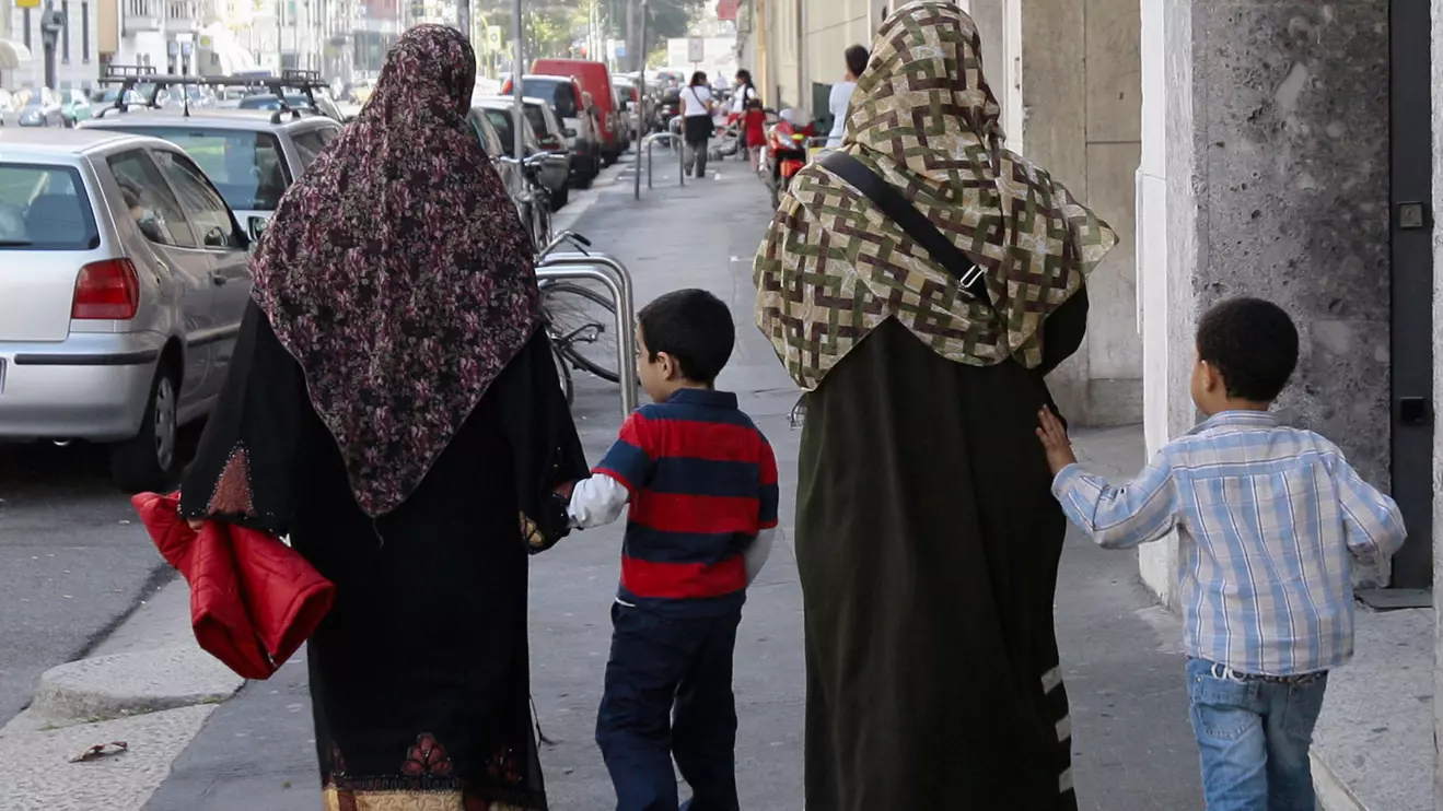 Two Muslim women wearing hijabs walk with children in Milan, Reuters/Alessandro Garofalo