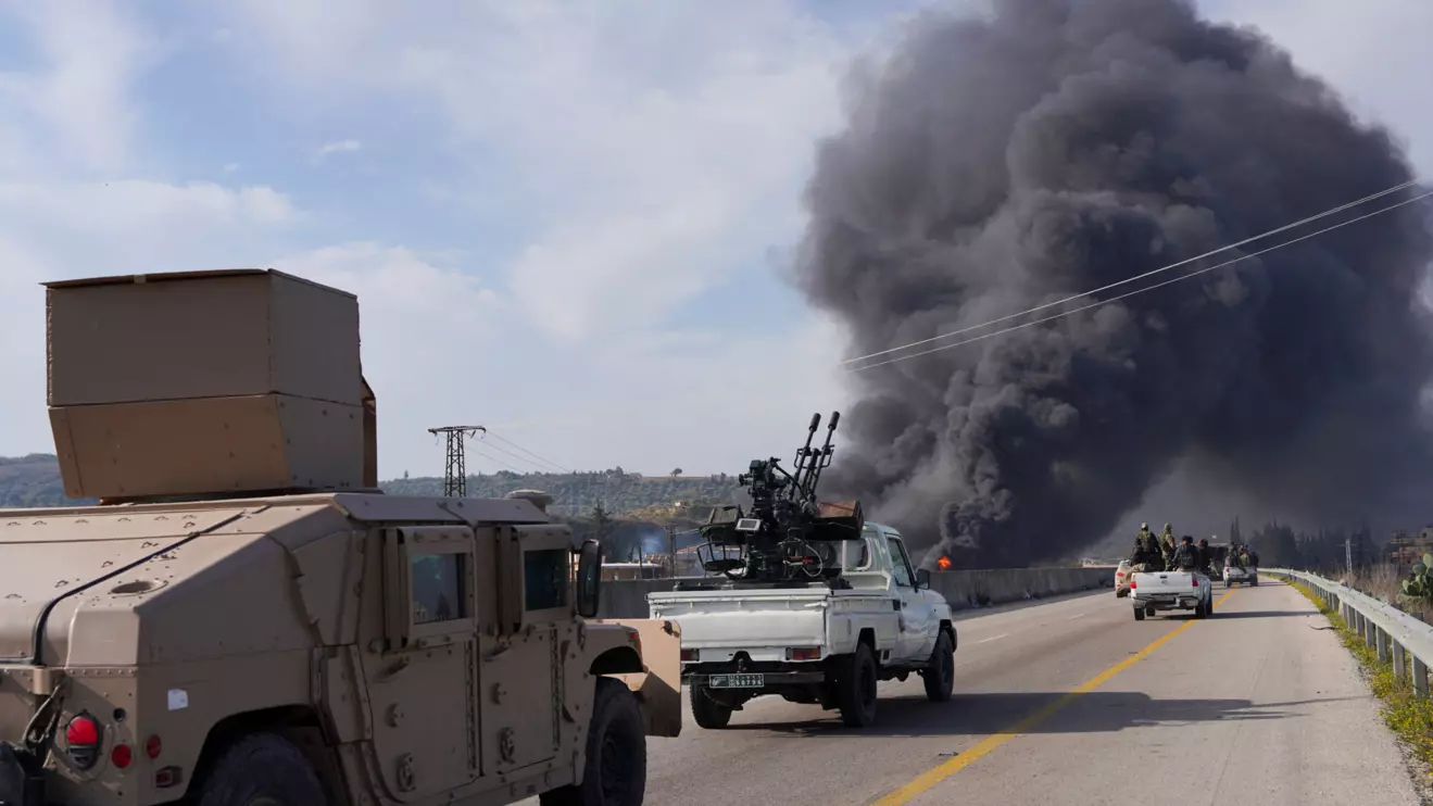 Smoke rises while members of the Syrian forces ride on a vehicle as they battle against a nascent insurgency by fighters from ousted leader Bashar al-Assad's Alawite sect, in Latakia, Syria March 7, 2025. Reuters/Karam al-Masri