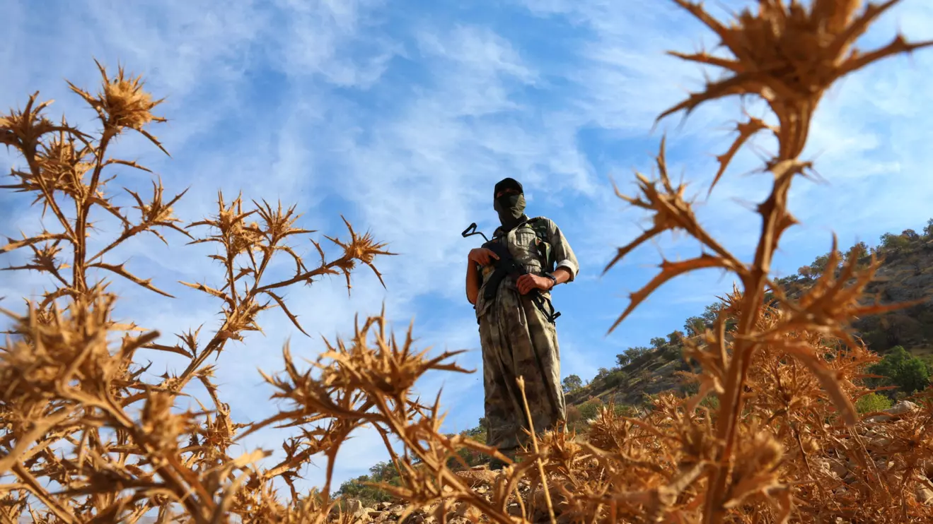 A fighter with the Kurdistan Workers' Party (PKK) stands guard during a disarmament process marking a significant step toward ending the decades-long conflict between Turkey and the outlawed group, in the Qandil mountains, Iraq, October 26, 2025. Reuters/Thaier Al-Sudani