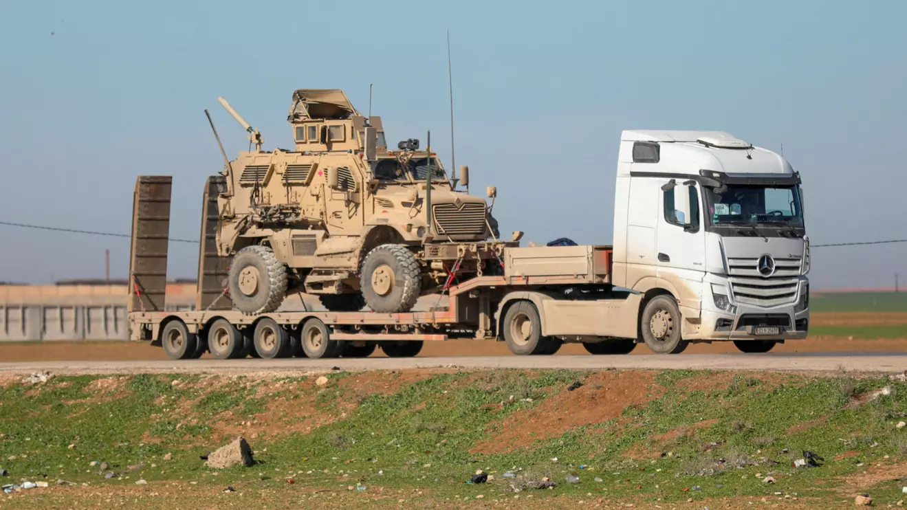 A trailer carries an armoured U.S. military vehicle as U.S. troops move towards the Iraqi Kurdistan region, withdrawing from Qasrak military base in northeastern Syria, in Qamishli, Syria, February 23, 2026. Reuters/Orhan Qereman