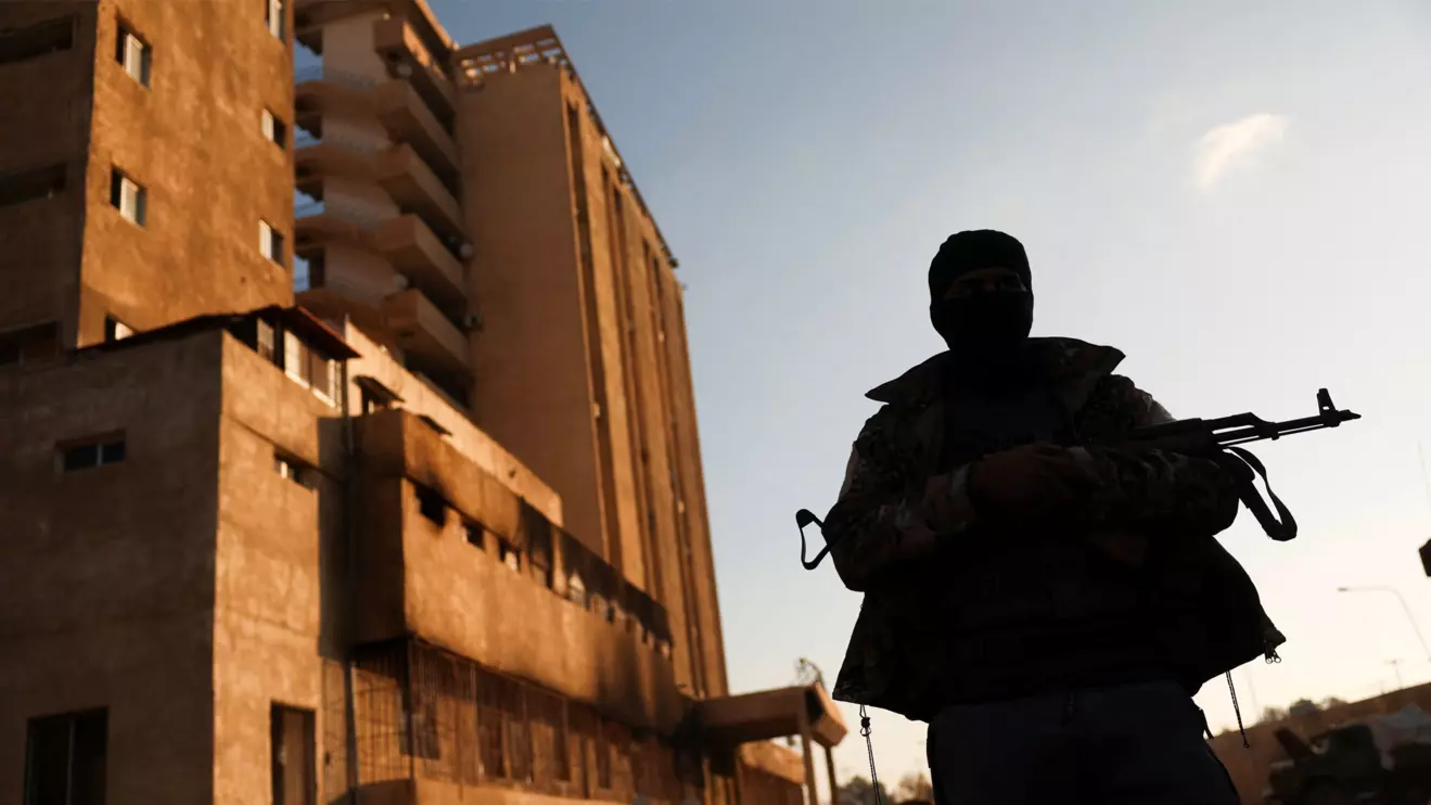 A fighter with Hayat Tahrir al-Sham (HTS) stands outside the Palestine Branch security complex in Damascus, Syria, December 13, 2024. Reuters/Amr Alfiky