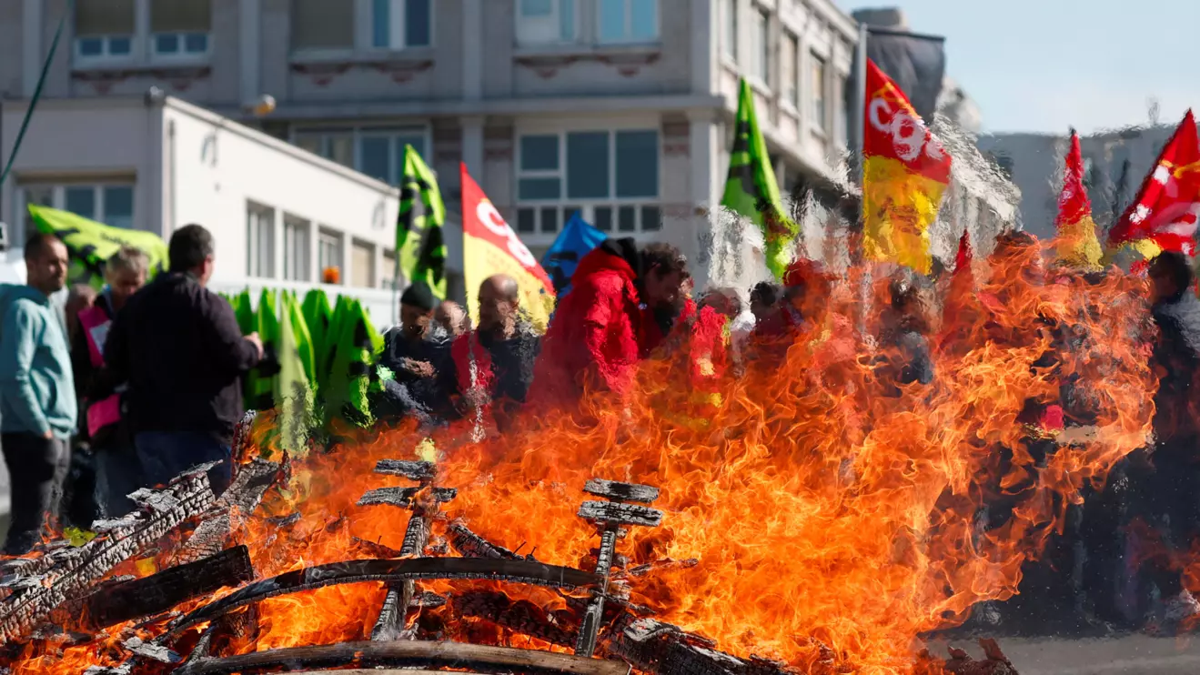 French SNCF railway workers on strike, holding flags of French CGT and Sud Rail labour unions, gather near burning wooden pallets at Gare de Lyon train station as part of a "day of expression of railway anger" following months of strikes and a failed attempt to halt pension reforms, in Paris, France, April 20, 2023. Reuters/Benoit Tessier