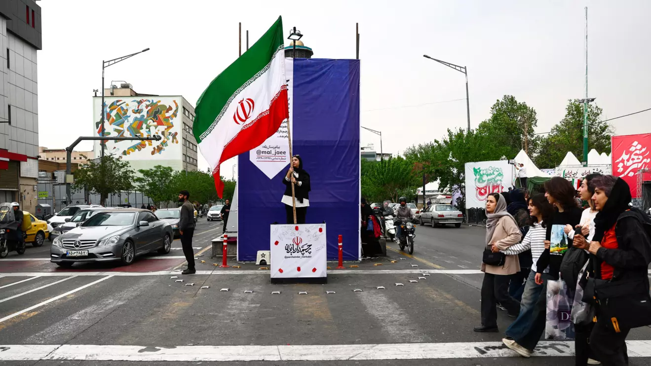 A woman holds an Iranian flag on a street, amid a ceasefire between U.S. and Iran, in Tehran, Iran, April 20, 2026. Majid Asgaripour/WANA (West Asia News Agency) via Reuters
