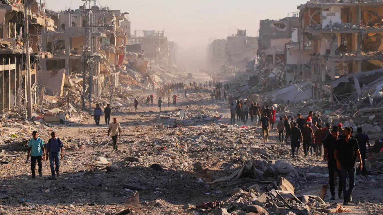 Palestinians walk through a damaged neighborhood in the aftermath of an Israeli operation, after Israel's government ratified a ceasefire with Hamas, in Gaza City October 10, 2025. Reuters/ Ebrahim Hajjaj