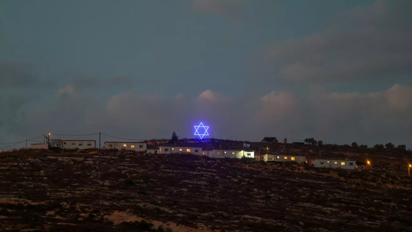 An illuminated Star of David above an Israeli settlers outpost near Ramallah, in the Israeli-occupied West Bank, August 14, 2026. Reuters/Ammar Awad