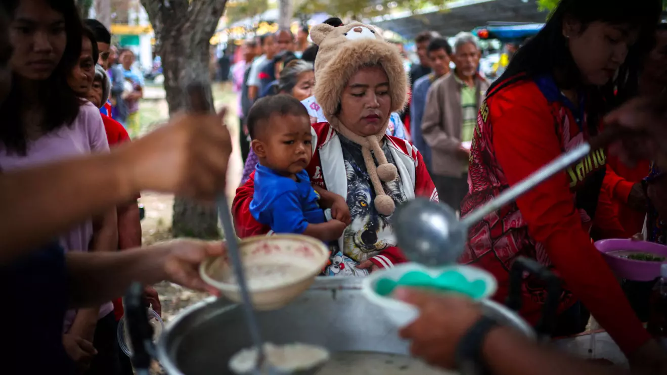 Displaced people queue for food at a school turned temporary shelter, amid clashes between Thailand and Cambodia along a disputed border area in Surin province, Thailand. Reuters/Athit Perawongmetha
