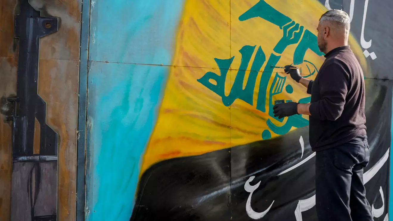 A man paints a Hezbollah flag on a board, in Tyre, south Lebanon, April 14, 2026. Reuters/Louisa Gouliamaki