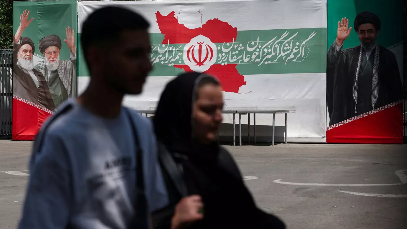 People walk past a banner with pictures of the late leader of the Islamic Revolution, Ayatollah Ruhollah Khomeini, the late Iran's Supreme Leader Ayatollah Ali Khamenei, and Iran's Supreme Leader Mojtaba Khamenei, on a street in Tehran, Iran, June 9, 2026. Majid Asgaripour/WANA (West Asia News Agency) via Reuters