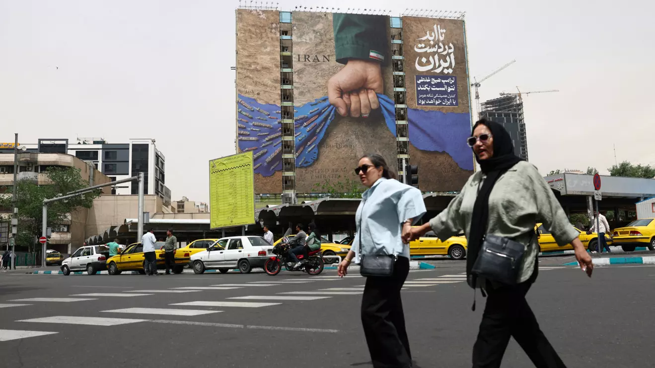 People walk past a billboard with a graphic design about the Strait of Hormuz on a building, in Tehran, Iran, May 4, 2026. Majid Asgaripour/WANA (West Asia News Agency) via Reuters