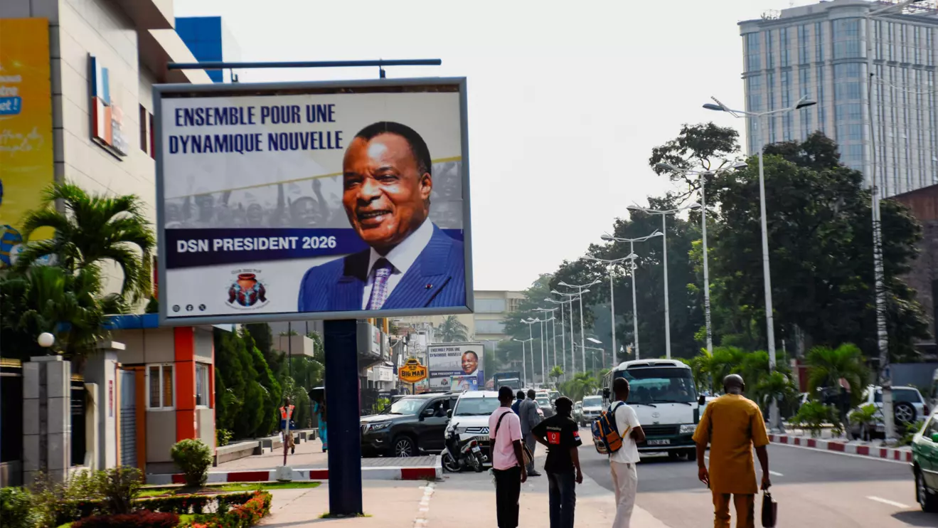 People walk past a campaign billboard of outgoing President Denis Sassou Nguesso, who is running for re‑election, ahead of the March 15 presidential election, in Brazzaville, Congo Republic, March 2, 2026. Reuters/Roch Bouka