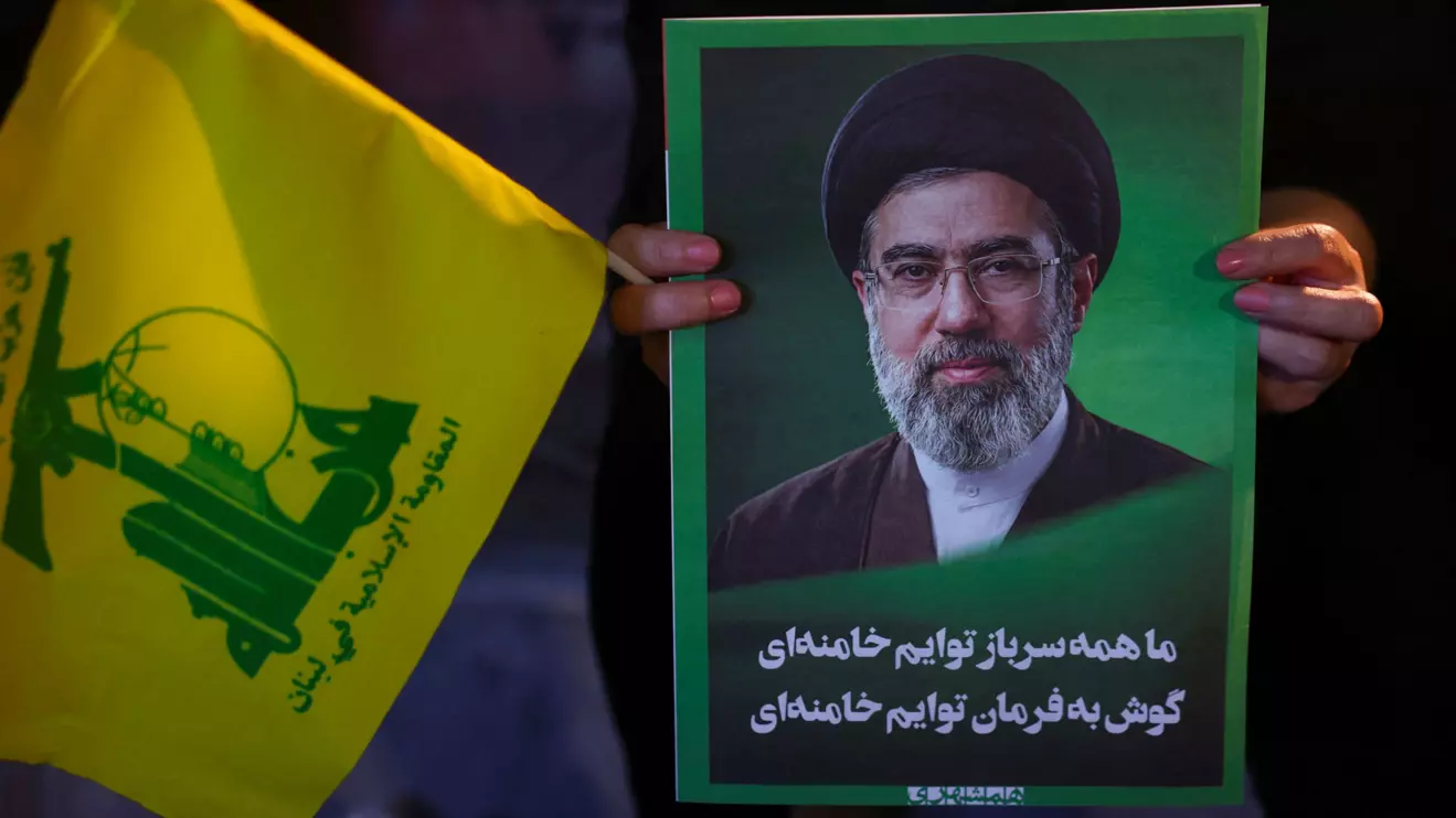 A woman holds an image of Iran's Supreme Leader, Mojtaba Khamenei, and a Hezbollah flag during a rally in Tehran, Iran, June 1, 2026. Majid Asgaripour/WANA (West Asia News Agency) via Reuters