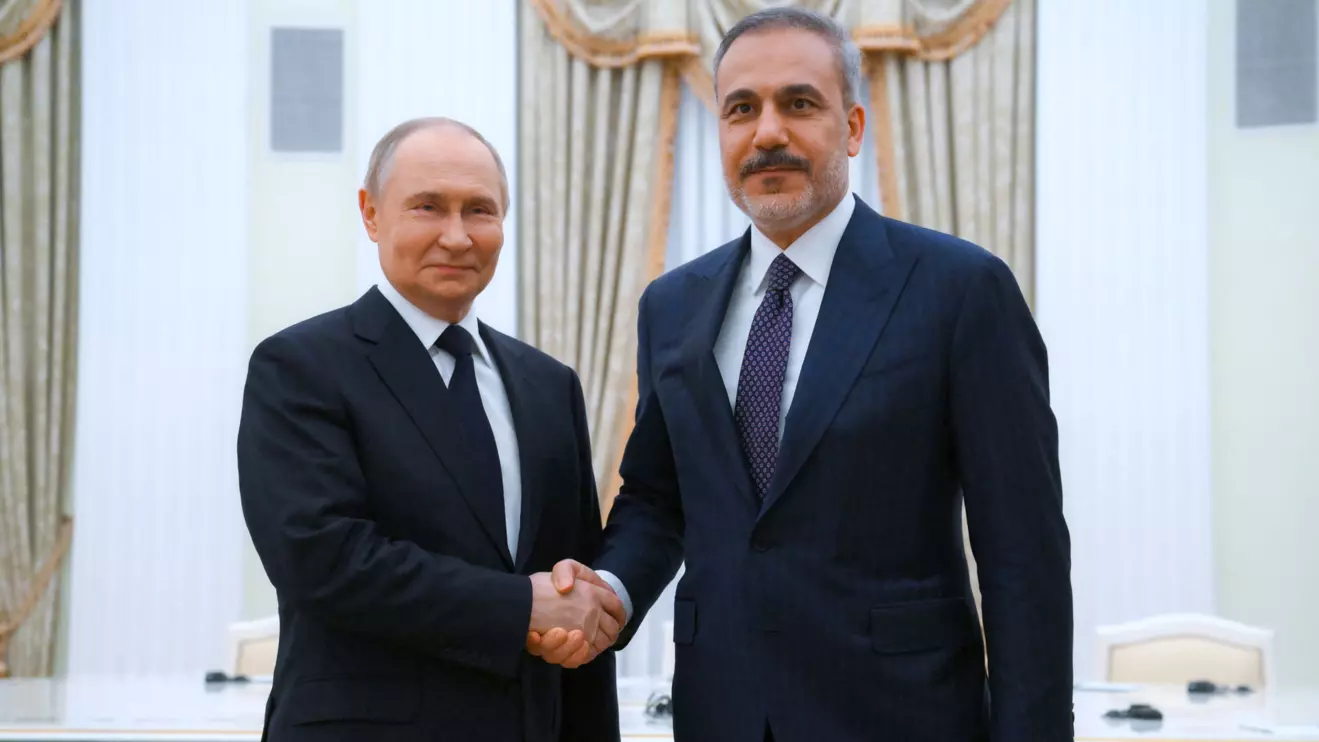 Russian President Vladimir Putin and Turkish Foreign Minister Hakan Fidan shake hands as they pose for photos before a meeting at the Kremlin in Moscow, Russia May 26, 2025. Sputnik/Alexey Maishev/Pool via Reuters