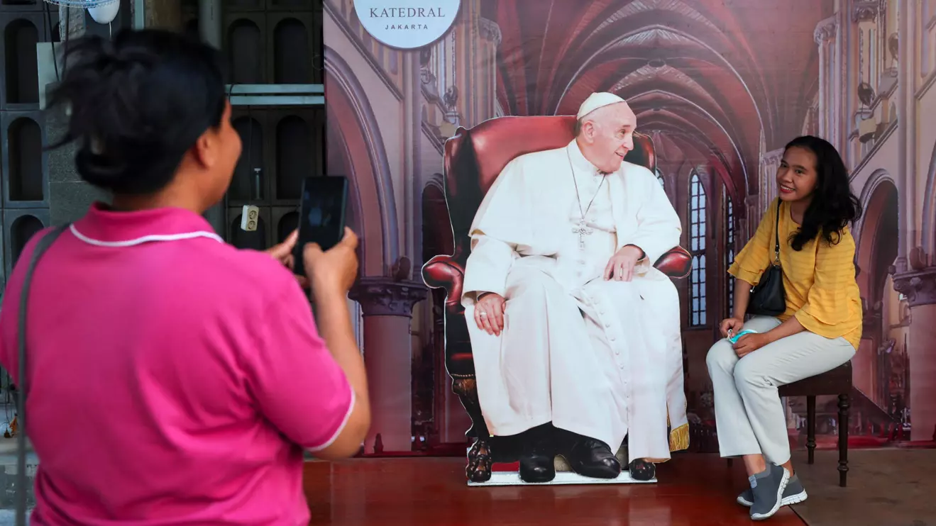 A person poses with a cutout depicting Pope Francis at Jakarta Cathedral ahead of his visit, in Jakarta, Reuters/Ajeng Dinar Ulfiana
