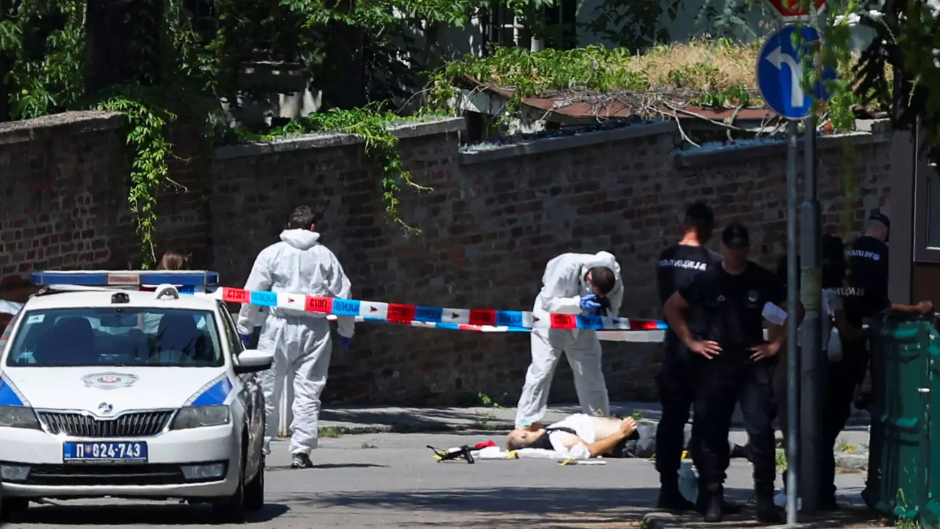 A person lies on the ground, as police officers guard the area after an attack, near the Israeli embassy in Belgrade, Serbia, June 29, 2024. Reuters/Zorana Jevtic