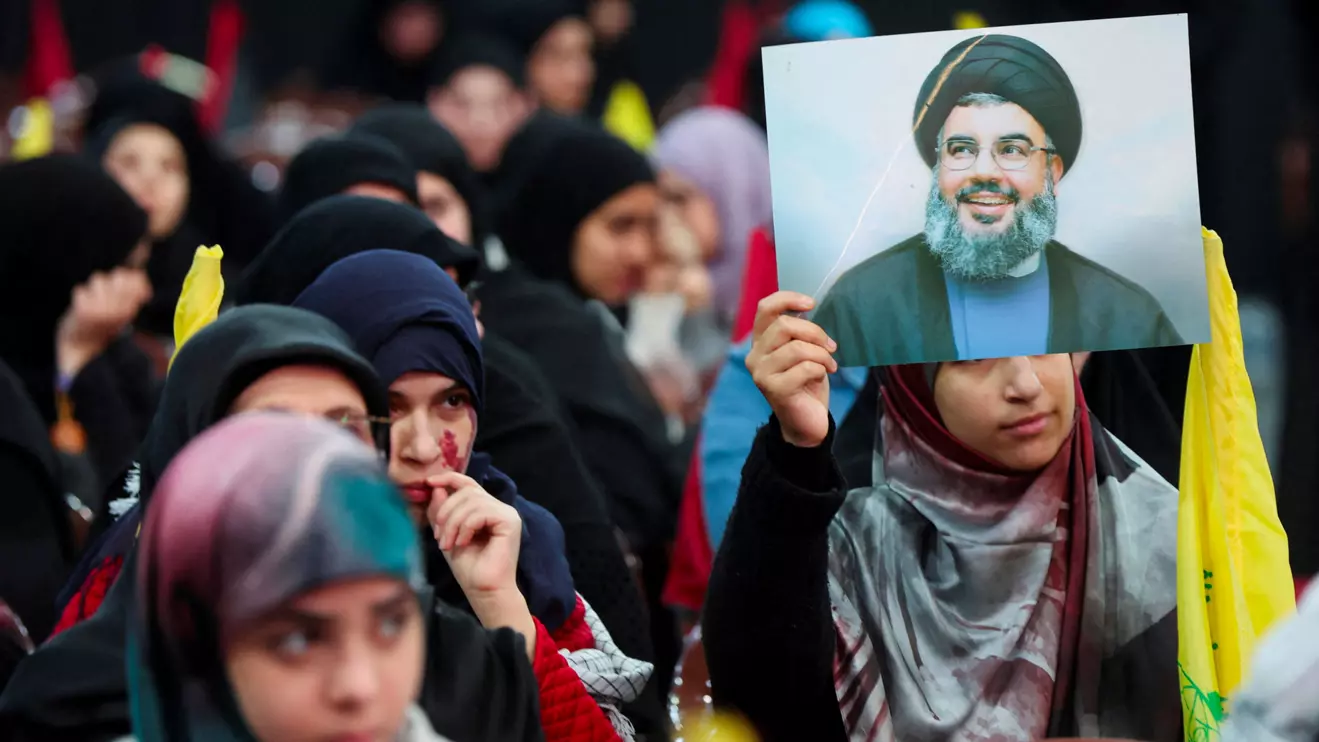 A supporter of Lebanon's Hezbollah leader Sayyed Hassan Nasrallah holds his picture during a rally commemorating the group's late leaders in Beirut's southern suburbs, Lebanon February 16, 2024. Reuters/Mohamed Azakir