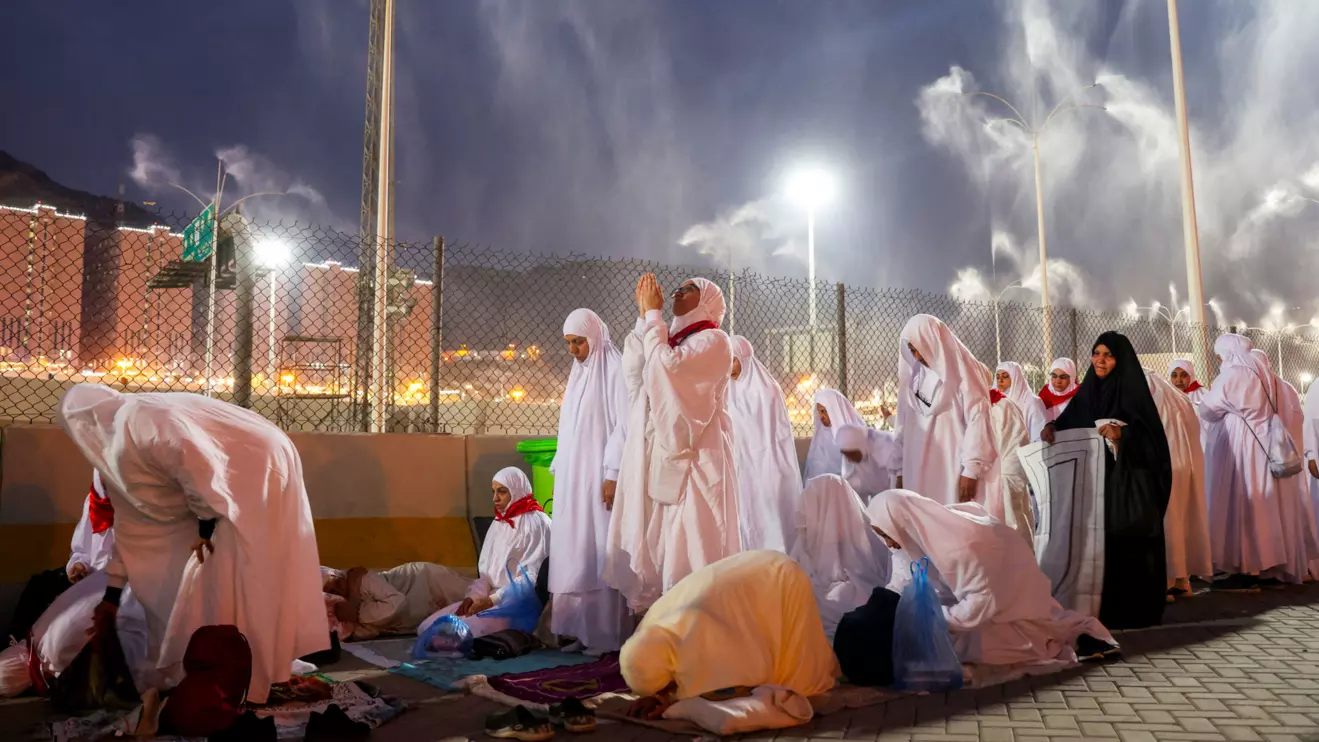 Muslim pilgrims pray as sprinklers spray water to cool them down amid extremely hot weather, during the annual haj pilgrimage, in Mina, Saudi Arabia, June 16, 2024. Reuters/Saleh Salem