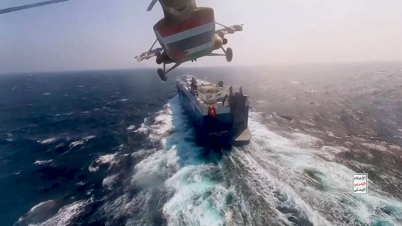 Houthi military helicopter flies over the Galaxy Leader cargo ship in the Red Sea in this photo released November 20, 2023. Houthi Military Media/Handout via Reuters