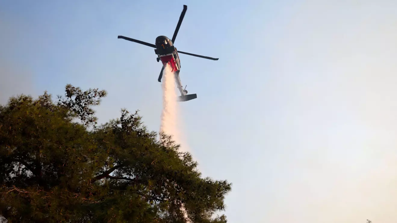 A firefighting helicopter drops water to extinguish fire at the area of Souni near Limassol, Cyprus July 24, 2025. Reuters/Yiannis Kourtoglou