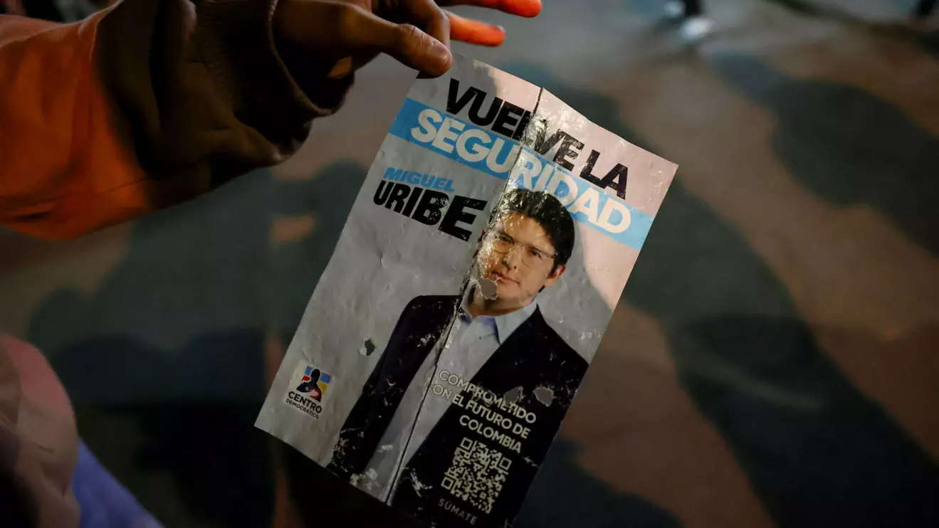 A persin holds a campaign poster at the area where Colombian Senator Miguel Uribe Turbay of the opposition Democratic Center party, was shot during a campaign event, in Bogota, Colombia, June 7, 2025. Reuters/Luisa Gonzalez