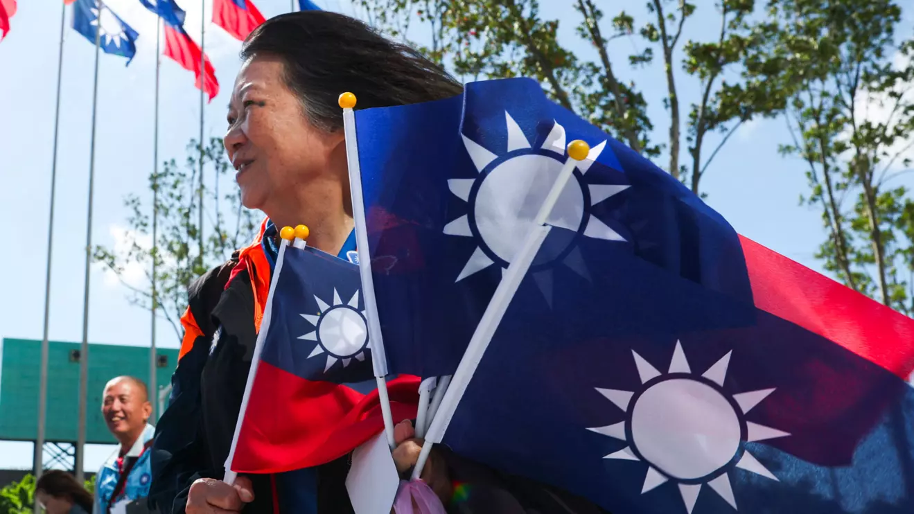 A woman holds flags amid celebrations of the 130th foundation anniversary of Taiwan's largest opposition party Kuomintang (KMT), in Taoyuan, Taiwan November 24, 2024. Reuters/Ann Wang