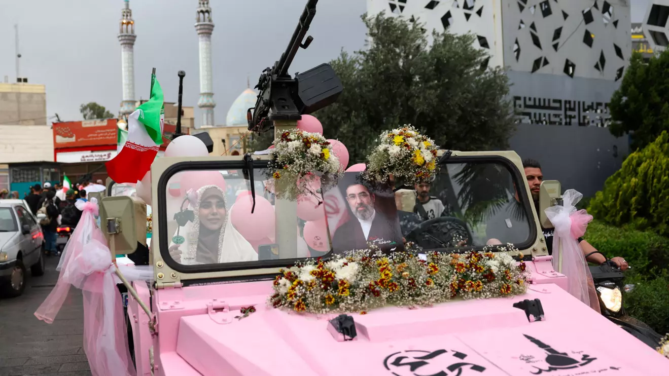 An Iranian couple arrive on a military vehicle during a public wedding ceremony called "Sacrificed couple wedding", in Tehran, Iran, May 18, 2026. Majid Asgaripour/WANA via Reuters