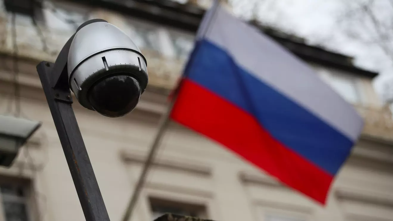 A security camera is seen, and a flag flies outside the consular section of Russia's embassy in London, Britain, March 15, 2018. Reuters/Hannah McKay
 
