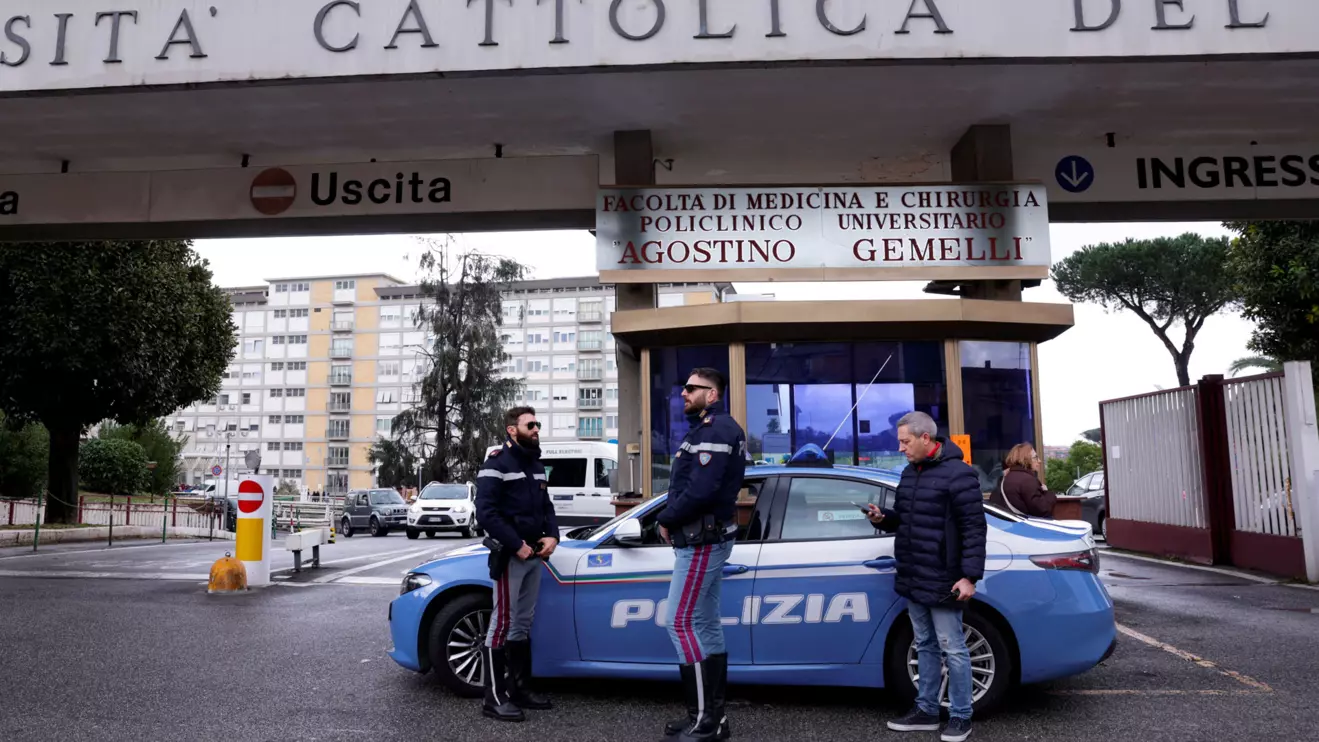 Police members stand next to a car outside the Gemelli Hospital where Pope Francis has gone to continue treatment for ongoing bronchitis in Rome, Italy, February 14, 2025. Reuters/Remo Casilli