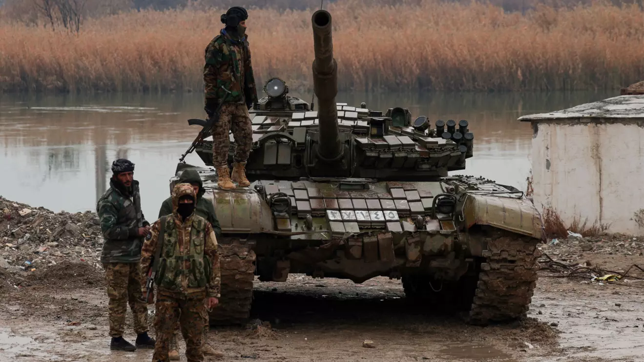 Military personnel stand at the crossing connecting the two banks of the Euphrates River, as others attempt to cross to the other side after the Syrian Democratic Forces (SDF) withdrew from Deir al-Zor province and the Syrian army took full control over the area, in Deir al-Zor, Syria, January 18, 2026. Reuters/Khalil Ashawi