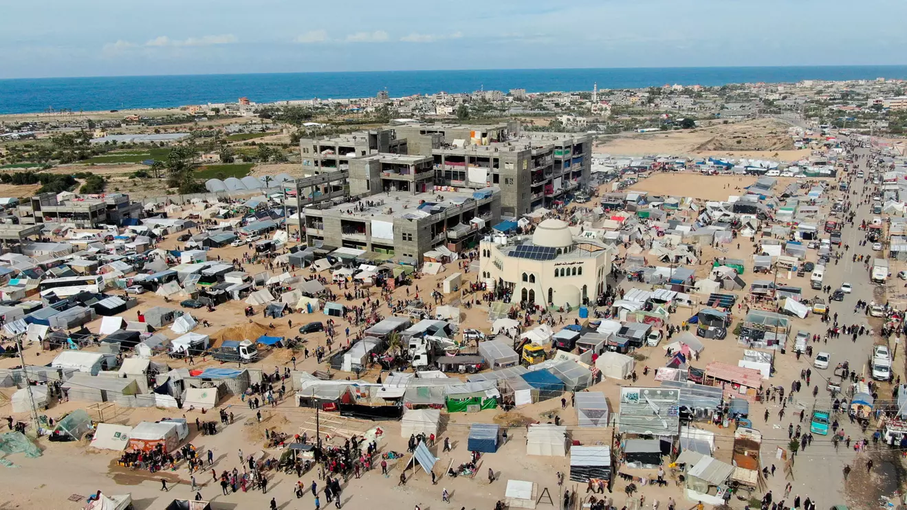 People walk near tent camps where displaced Palestinians, who fled their houses due to Israeli strikes amid the ongoing conflict between Israel and the Palestinian Islamist group Hamas, take shelter in Rafah in the southern Gaza Strip, December 9, 2023. Reuters/Mustafa Thraya