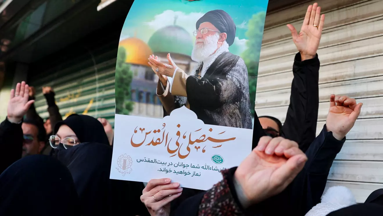 A woman holds a poster with the picture of Iran's Supreme Leader Ayatollah Ali Khamenei as people gather after Khamenei was killed in Israeli and U.S. strikes on Saturday, in Tehran, Iran, March 1, 2026. Majid Asgaripour/WANA (West Asia News Agency) via Reuters
